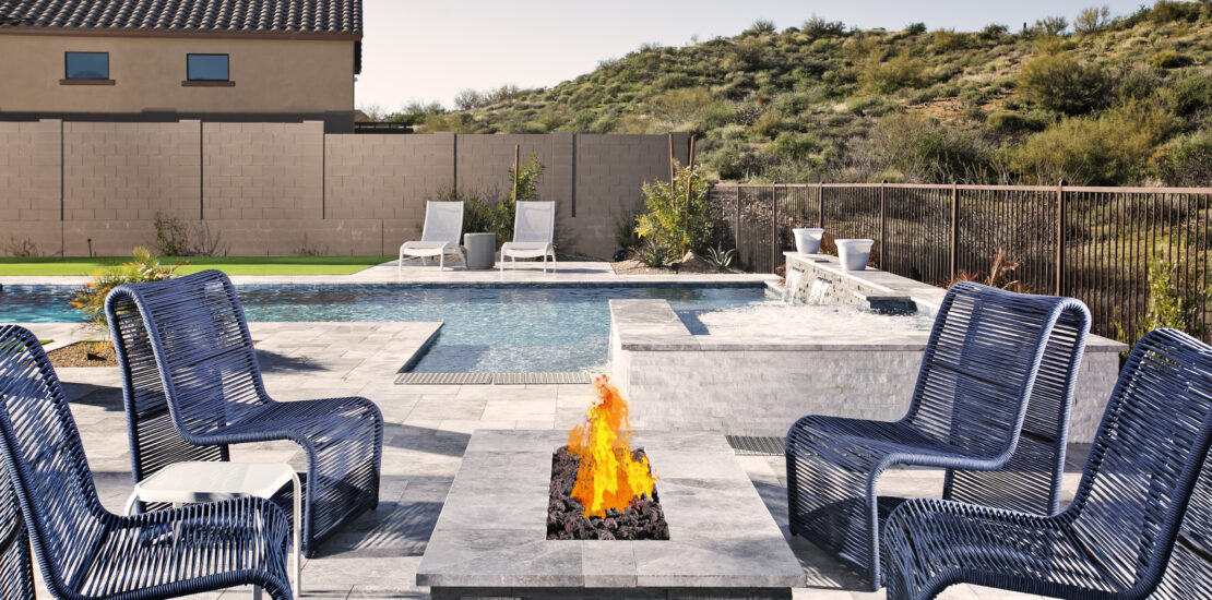 Outdoor fire pit surrounded by chairs and landscaped yard