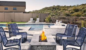 Outdoor fire pit surrounded by chairs and landscaped yard