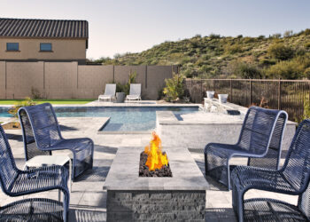 Outdoor fire pit surrounded by chairs and landscaped yard